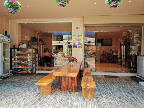 a store with two wooden benches in front of a store at SorotHouse in Jomtien Beach