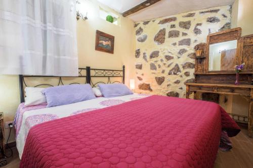 1 dormitorio con 1 cama grande con manta roja en Casa Amparo, en Icod de los Vinos