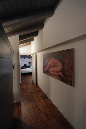 a hallway with a painting of a woman on a wall at Albergo al Vecchio Tram in Udine