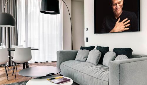 a living room with a couch and a picture of a man at Hotel Gartner in Tirolo