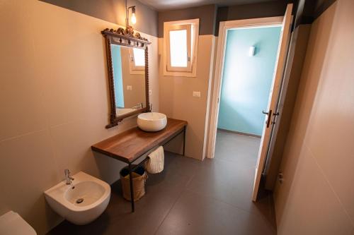 uma casa de banho com um lavatório, um espelho e um WC. em Le Masserie Zucaro em Castel del Monte