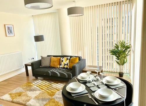 a living room with a table and a couch at Smartrips Apartments - The Hub in Milton Keynes