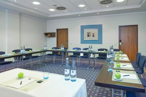 a conference room with long tables and chairs at Dorint Hotel am Dom Erfurt in Erfurt