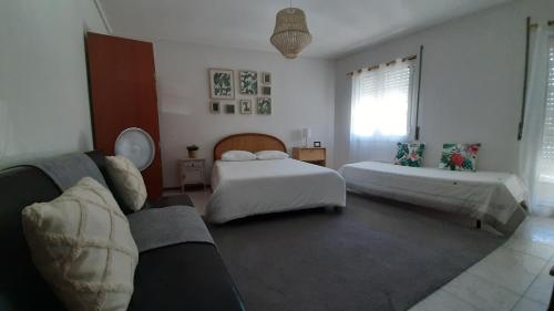 uma sala de estar com duas camas e um sofá em Feel Aveiro - Church View em Aveiro