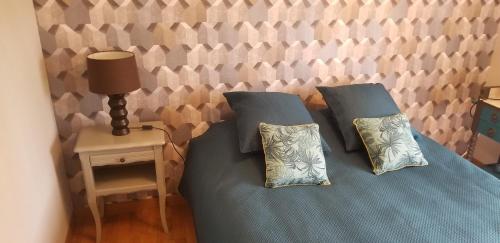 - une chambre avec 2 lits avec des oreillers et une table dans l'établissement Chambre d'hôtes Morbihan Gwenva, à Sainte-Brigitte