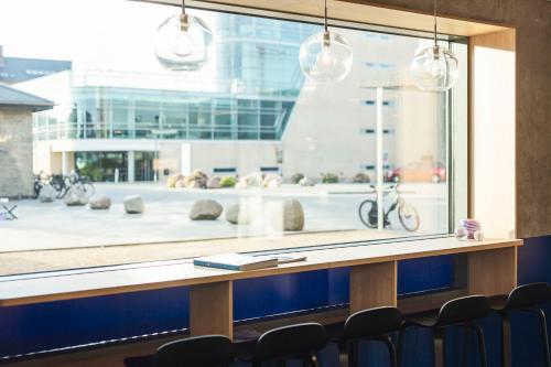 a table with chairs in front of a large window at CPH Hotel in Copenhagen