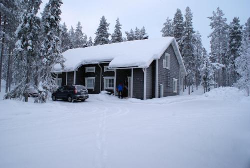 a cabin in the snow with a car parked in front at Ettomies II in Äkäslompolo