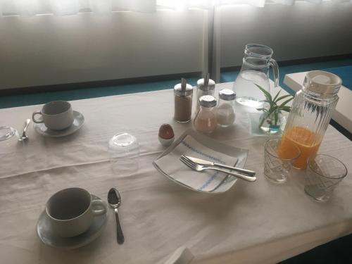a table with a plate and a cup of orange juice at Azafrán Consuegra in Consuegra
