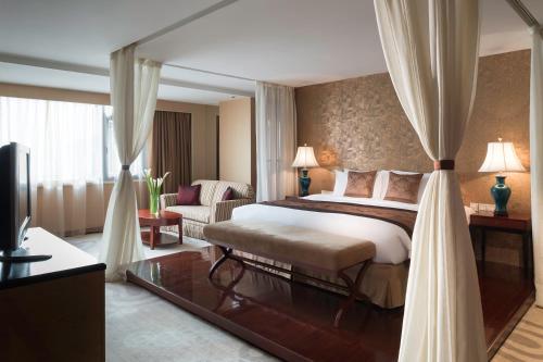 um quarto de hotel com uma cama e um sofá em Wyndham Garden Suzhou em Suzhou