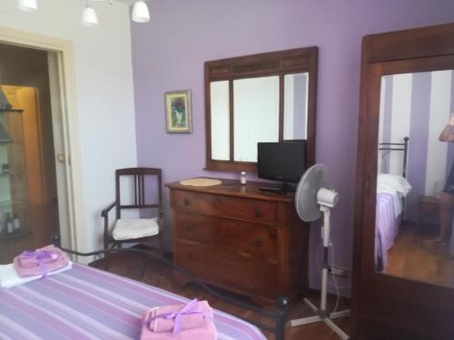 1 dormitorio con 1 cama y vestidor con TV en B&B Ariadamare, en San Remo