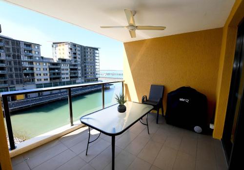 a balcony with a table and a view of the ocean at WATERFRONT DARWIN TROPICAL DELIGHT in Darwin