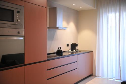 a kitchen with a stove and a microwave at SETTANNI Sea Suites in Polignano a Mare