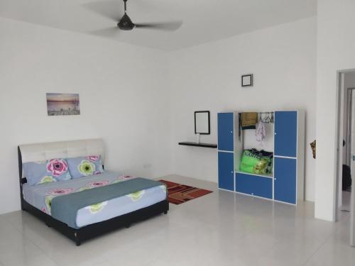 a bedroom with a bed and a refrigerator at Fathullah's Homestay in Alor Setar