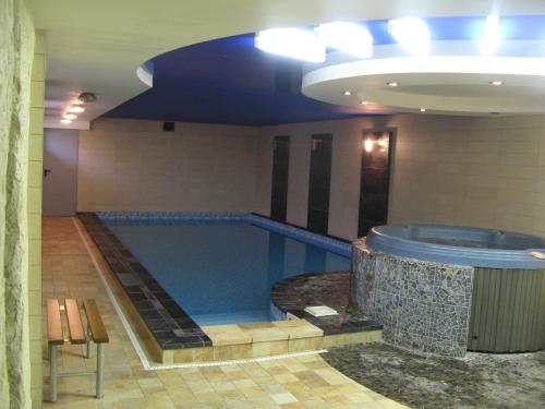 a large swimming pool in a building with a tub at Nidos Poilsine Studio in Nida