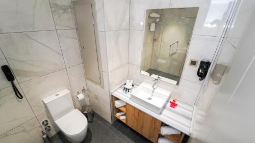 a white bathroom with a toilet and a sink at Grand Sirkeci Hotel in Istanbul