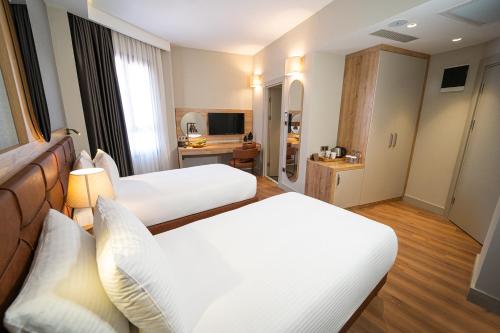 a hotel room with two beds and a television at Grand Sirkeci Hotel in Istanbul
