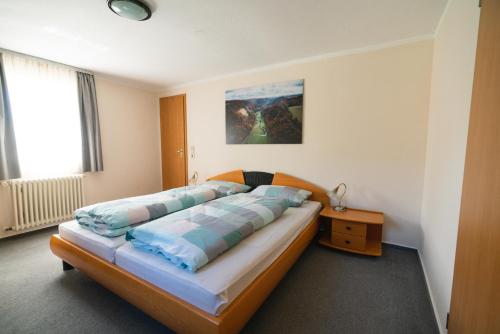 ein Schlafzimmer mit einem Bett mit blauen Kissen darauf in der Unterkunft Ferienwohnung Lautertal Haus Barbara in Indelhausen