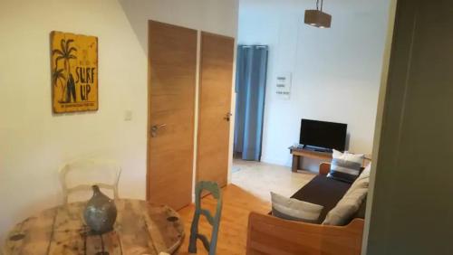 un salon avec une table et un canapé dans l'établissement Les Dunes accès direct mer, à Sangatte