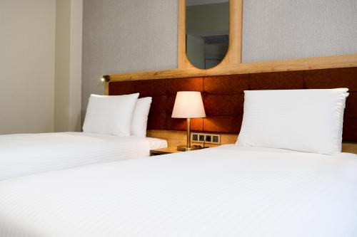 two beds in a hotel room with a mirror at Grand Sirkeci Hotel in Istanbul