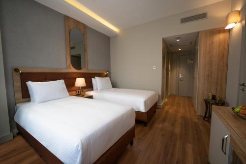a hotel room with two beds and a mirror at Grand Sirkeci Hotel in Istanbul