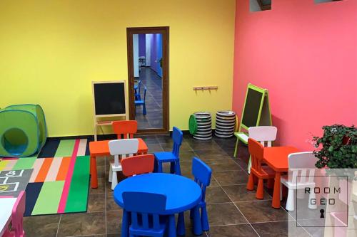 a room with colorful chairs and tables and a tv at ORBI Palace Deluxe in Bakuriani