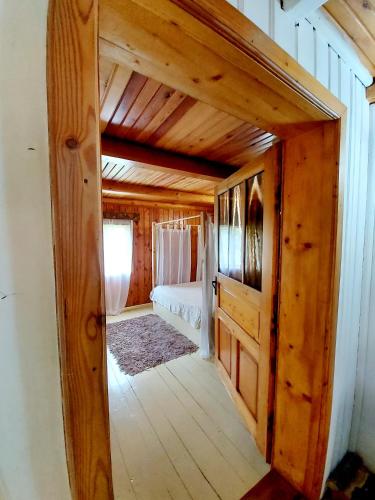 a bedroom with a bed in a wooden house at Fisherman's Cottage in Cacica