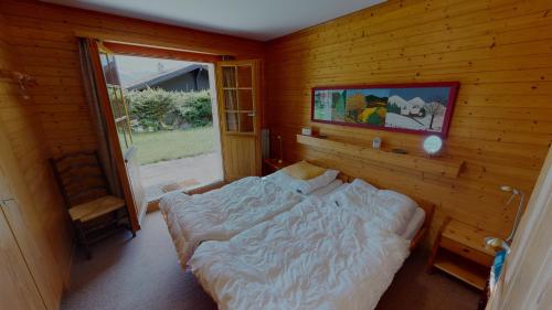 ein Schlafzimmer mit einem Bett in einer Holzwand in der Unterkunft Casa Beata CB0 in Blatten bei Naters