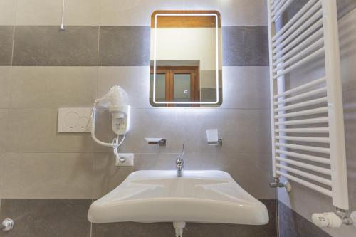 La salle de bains est pourvue d'un lavabo et d'un miroir. dans l'établissement Albergo Diffuso Amatrice, à Amatrice