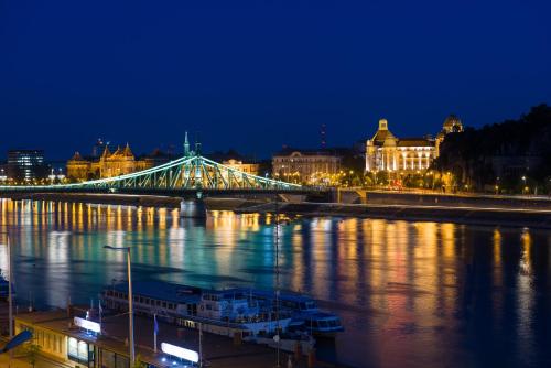a bridge over a river at night with buildings at Hotel Vision Budapest by Continental Group in Budapest