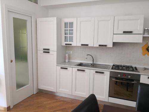 努馬納的住宿－Grazioso appartamento in Centro a Numana，白色的厨房配有白色橱柜和水槽