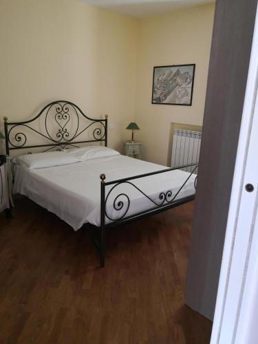 努馬納的住宿－Grazioso appartamento in Centro a Numana，卧室配有一张带白色床单和木地板的大床。
