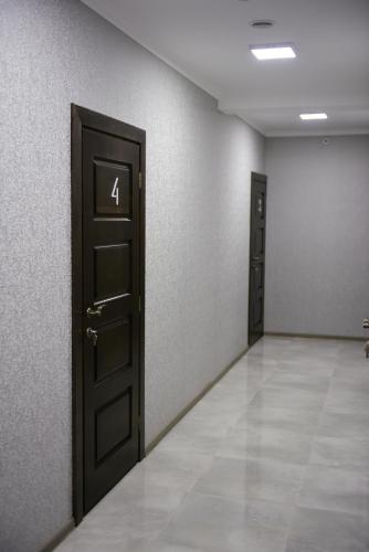 an empty room with two doors and a tile floor at Gray Hotel in Vynohradiv