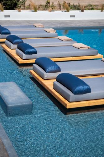 a row of inflatable mattresses in a swimming pool at Volcanic Arc Suites in Oia