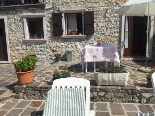 a table and chairs on a patio with a table and flowers at Casa Mary in Brenzone sul Garda