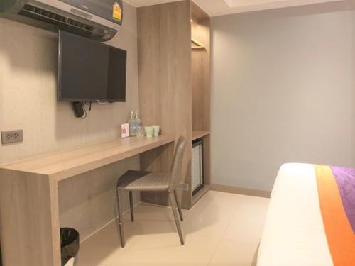 a room with a desk with a tv and a bed at Studio Ekamai in Bangkok