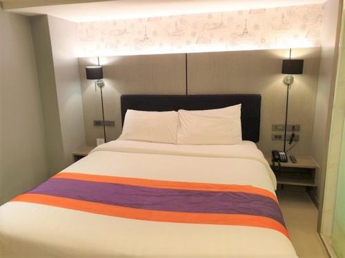 a bedroom with a large bed with a colorful blanket at Studio Ekamai in Bangkok