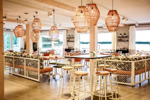 un restaurante con mesas, sillas y lámparas de araña en Maremüritz Yachthafen Resort, en Waren