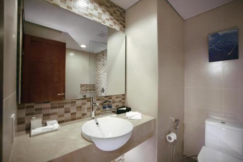 a bathroom with a sink and a toilet at Aston Bojonegoro City Hotel in Bojonegoro