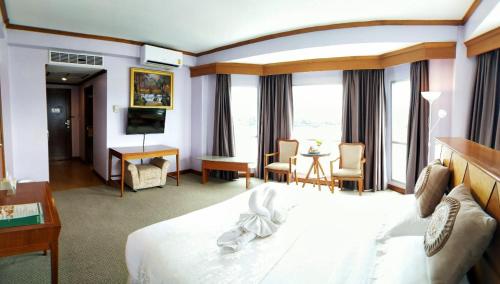 a hotel room with a bed with a bunny on it at Viang Tak Riverside Hotel in Tak