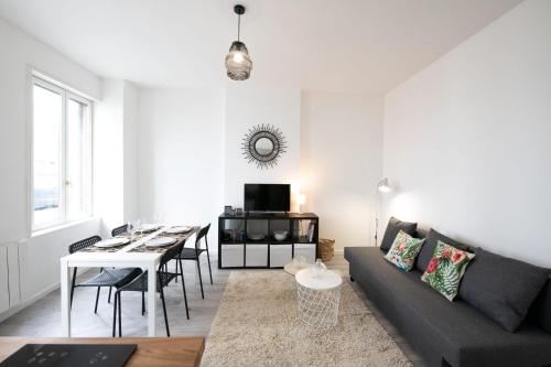 a living room with a couch and a table at Le Mille - Cosy appartement 4 personnes - 15mn du centre de Lyon in Villeurbanne