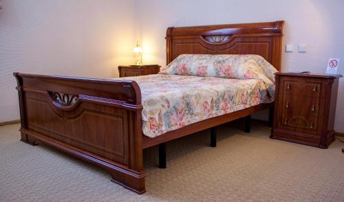 a bedroom with a wooden bed and two night stands at Astoria Lux in Dnipro