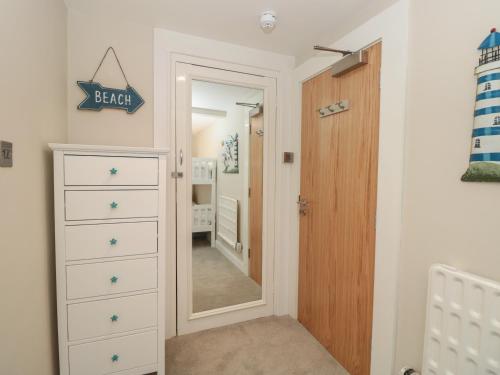 a baby room with a dresser and a mirror at 37 The Salcombe in Salcombe