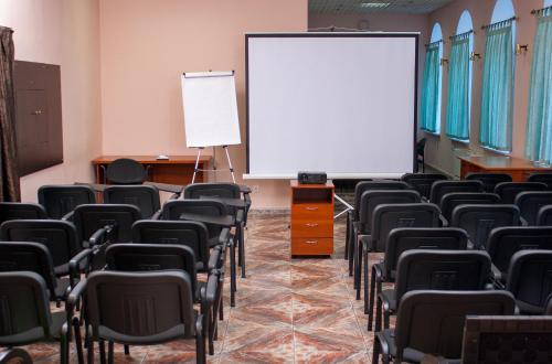 an empty room with chairs and a white screen at Astoria Lux in Dnipro