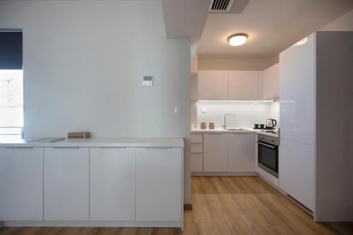 a white kitchen with white cabinets and a stove at Athens Panorama Project in Athens