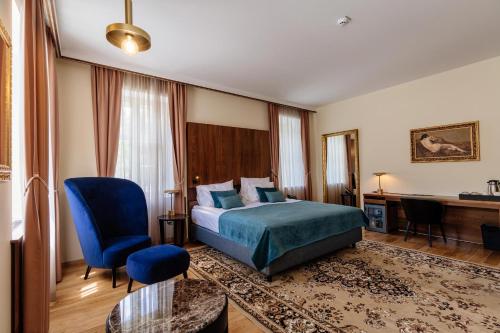 a hotel room with a bed and a desk at Boutique Hotel Dobrna - Terme Dobrna in Dobrna