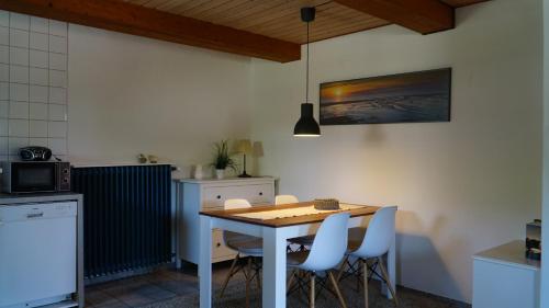 een keuken met een tafel en stoelen in een kamer bij Landhaus Gonnsen in Emmelsbüll-Horsbüll