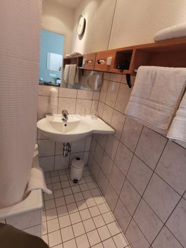 ein weißes Badezimmer mit Waschbecken und Toilette in der Unterkunft guestified AYUNA Hotel in Düsseldorf