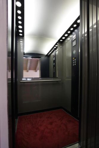 a hallway with an open door with a red carpet at Albergo al Vecchio Tram in Udine
