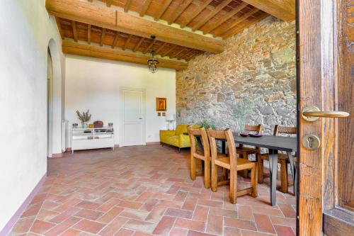 Un comedor con una pared de piedra y una mesa y sillas. en Villa Galgani, en Lucca