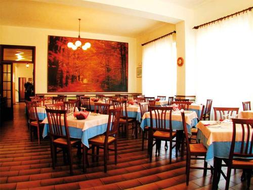 une salle à manger avec des tables, des chaises et un tableau dans l'établissement Hotel Parma Mare, à Marina di Massa